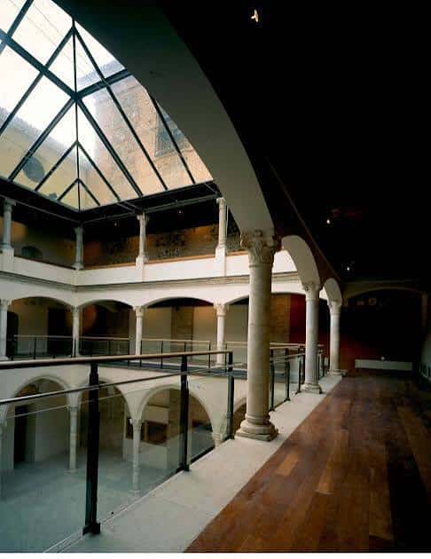 Interior moderno del edificio con techumbre de cristal y pasarelas de madera