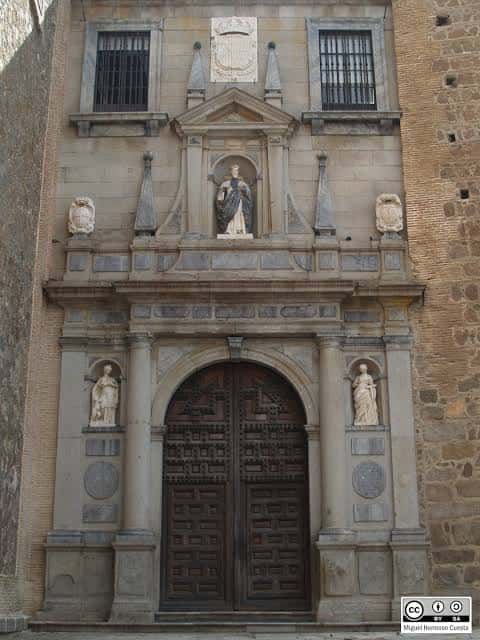 Fachada histórica con puerta de madera tallada y esculturas religiosas