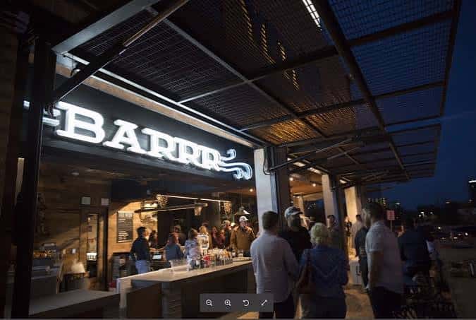 Vista nocturna de la barra BARRR con clientes