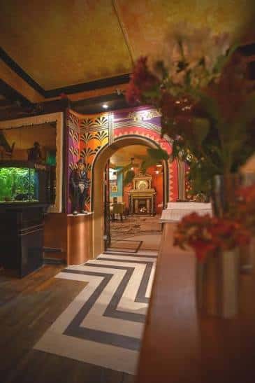 Interior del bar con decoración art deco y pasillo hacia el salón principal