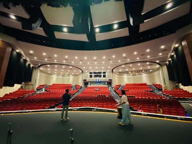 Interior del auditorio con butacas rojas y escenario