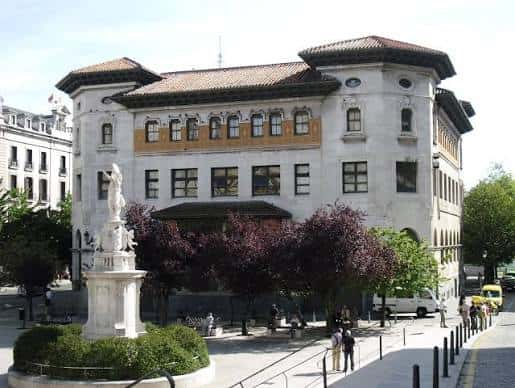 Fachada principal del edificio con plaza y fuente en primer plano
