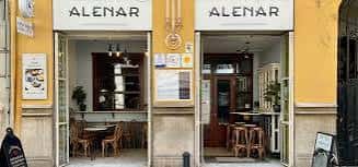 Vista diurna de la entrada principal de Alenar con mesas visibles y decoración tradicional valenciana