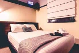 Habitación doble con cama grande y cortinas enrollables