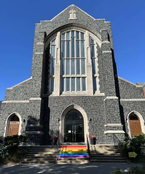 Fachada principal de la Catedral de Todos los Santos con arco gótico y bandera del orgullo