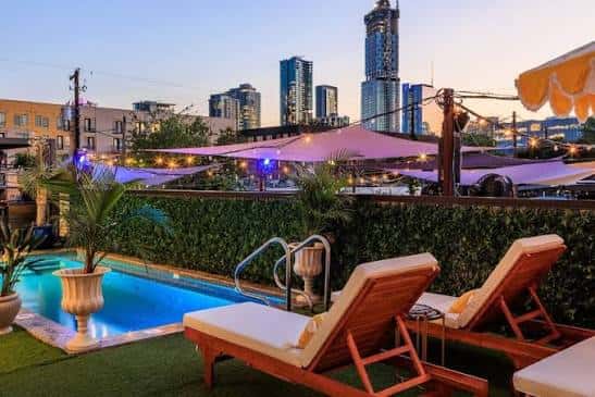 Piscina privada en la azotea con tumbonas y vista urbana