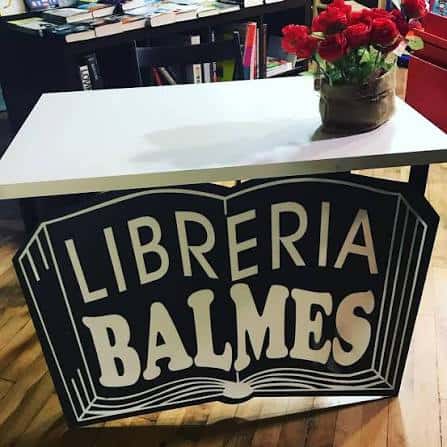 Detalle de un cartel decorativo con el nombre 'LIBRERIA BALMES' sobre una mesa