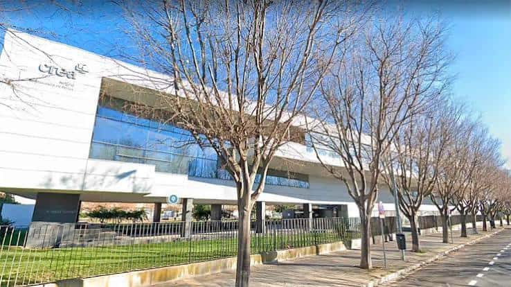 Vista exterior del complejo con árboles y señalización institucional
