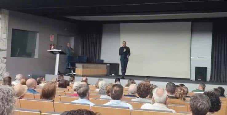 Evento en el auditorio con orador en escena y público sentado