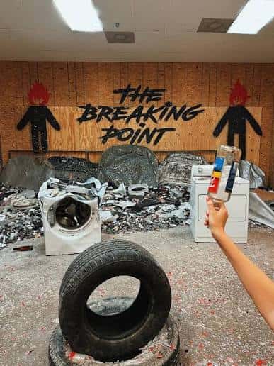 Interior del Rage Room Breaking Point con electrodomésticos destruidos y pared de madera