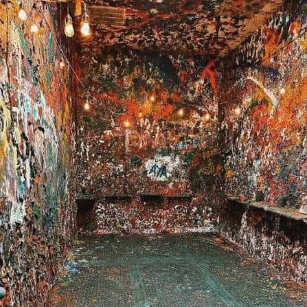 Sala de destrucción decorada con graffiti multicolor y luces colgantes