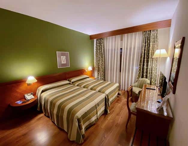 Habitación doble con decoración moderna y paredes verdes