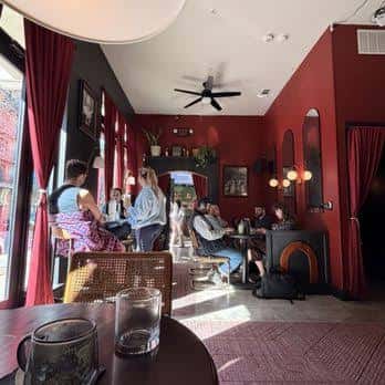 Interior acogedor de Klerje Coffee con paredes rojas y clientes disfrutando del ambiente