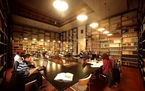 Sala de lectura con usuarios trabajando en mesas amplias