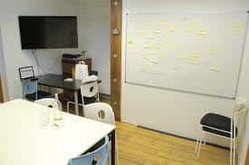 Sala de reuniones o espacio privado dentro de The Skiff con pizarra y mobiliario