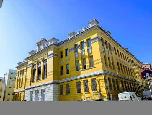Vista lateral del edificio amarillo con detalles arquitectónicos
