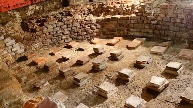 Vista aérea de las ruinas arqueológicas con muros de ladrillo y bases de columnas