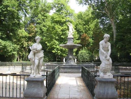 Fuente de la Dama del Lago rodeada de estatuas clásicas y vegetación exuberante
