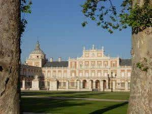 Fachada del palacio vista entre árboles, mostrando detalles arquitectónicos