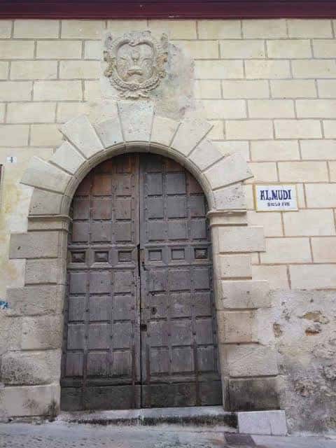 Detalle de la puerta principal con escudo y placa identificativa