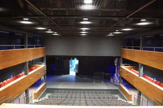 Escenario vacío con iluminación azul y estructura metálica visible