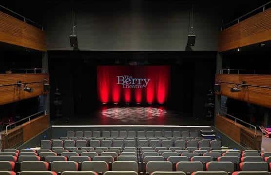Escenario con telón rojo y logotipo 'The Berry Theatre' iluminado