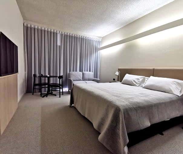 Habitación moderna del Toronto Hotel con cama doble, sofá y vista a la ventana