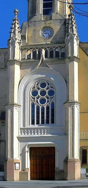 Detalle de la fachada principal con ventana circular y puerta de entrada