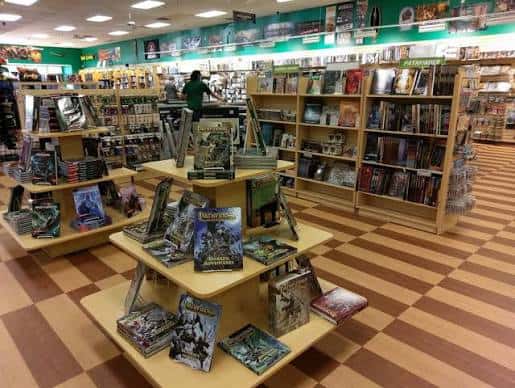 Interior de la tienda mostrando estanterías llenas de cómics y fantasía