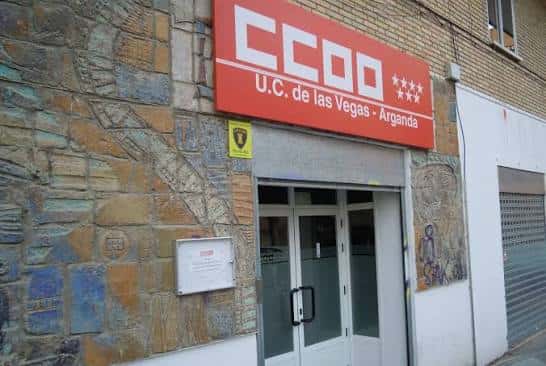 Entrada de la U.C. de las Vegas - Arganda con fachada de piedra y cartel CCOO