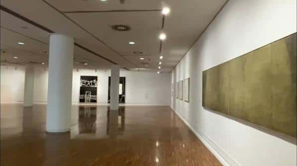 Espacio expositivo amplio con columnas blancas y obras colgadas en pared