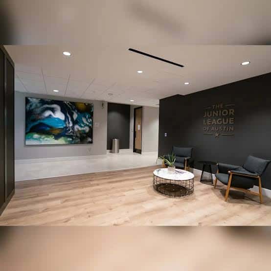 Interior del vestíbulo principal con arte contemporáneo, mobiliario moderno y logotipo de la organización en pared
