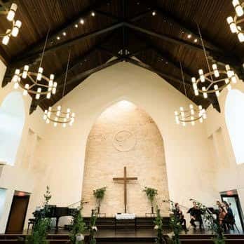 Interior de la capilla con techo abovedado y candelabros colgantes