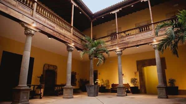 Patio interior con columnas de piedra y balcones de madera