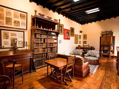Biblioteca antigua con estanterías llenas de libros y mobiliario clásico