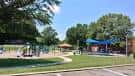 Área exterior del parque con juegos infantiles y zonas verdes