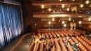 Interior del teatro desde la perspectiva de la platea, mostrando balcones y cortina azul