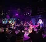 Concierto en vivo con banda actuando bajo luces de colores