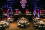 Configuración del salón para una cena o recepción con mesas redondas y luces decorativas