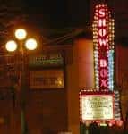 Vista nocturna de la fachada del Showbox con su icónico letrero vertical iluminado