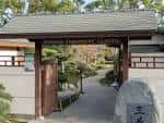 Entrada principal del Jardín Japonés con portón de madera y piedra