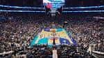 Interior del Spectrum Center durante un evento deportivo con cancha iluminada y gradería llena