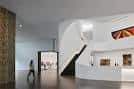Interior moderno del museo con escalera curva y obras expuestas