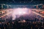 Concierto en vivo con iluminación dramática y público lleno