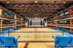 Interior del salón de eventos con estructura industrial y butacas azules