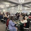 Evento social en el salón con invitados sentados a mesas redondas