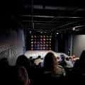 Interior del Rec Room Arts con escenario y público sentado