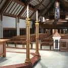 Nave central de la iglesia con bancos de madera y candelabros dorados