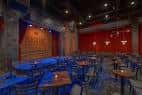 Interior del Punch Line Comedy Club Houston con mesas y escenario