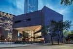 Vista exterior nocturna de la Biblioteca Central Jesse H. Jones con fachada moderna y luces cálidas